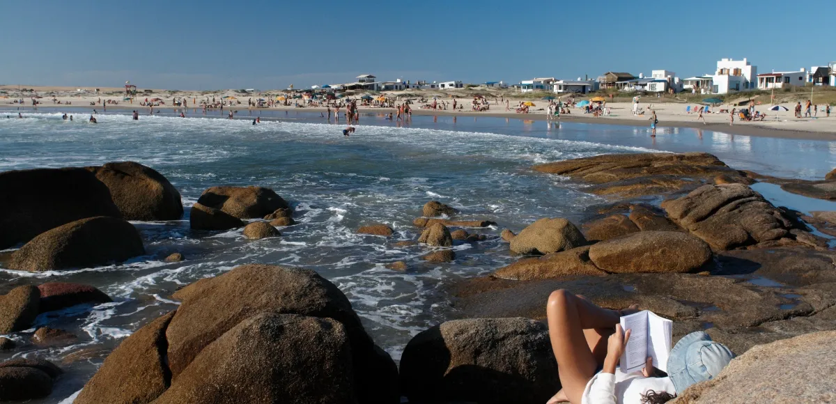 Mujer recostada en las rocas de la playa